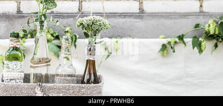 Hochzeit Einrichtung mit Flaschen und Blumen, das Konzept der Feierlichkeiten und Hochzeiten Stockfoto