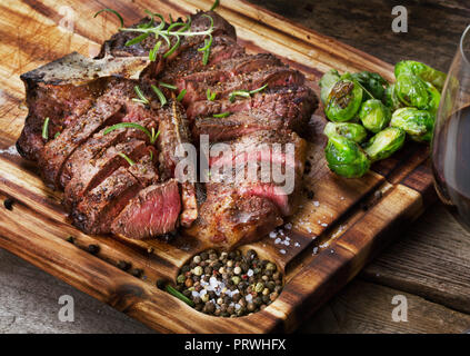 T-Bone Steak medium - Hinten mit Rosenkohl auf hölzernen Hintergrund Stockfoto