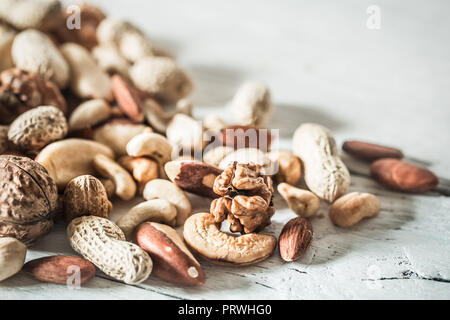 Verschiedene Nüsse closeup auf Holz- Hintergrund, Konzept der gesunden Ernährung Stockfoto