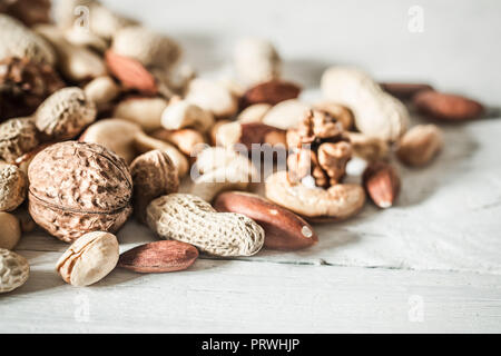 Verschiedene Nüsse closeup auf Holz- Hintergrund, Konzept der gesunden Ernährung Stockfoto