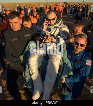 Zhezkazgan, Kasachstan. 4. Oktober 2018. Internationale Raumstation ISS Expedition 56 Commander Drew Feustel der NASA ist kurz nach der Landung an Bord des russischen Sojus MS-08 Raumschiff Oktober 4, 2018 in der Nähe von Zhezkazgan, Kasachstan zu einem medizinischen Zelt durchgeführt. Feustel und Ricky Arnold von NASA, zusammen mit russischen Sojus Commander Oleg Artemyev Rückkehr nach 197 Tagen im All. Credit: Planetpix/Alamy leben Nachrichten Stockfoto