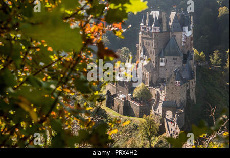 05 Oktober 2018, Rheinland-Pfalz, Wierschem: Die Sonne herrscht über die letzten Nebel Banken auf der Burg Eltz, während die Blätter der Bäume herbstliche drehen. In den kommenden Tagen die Temperaturen bis 23 Grad erreichen. Die mittelalterliche Burganlage ist eine der wichtigsten Sehenswürdigkeiten in Rheinland-Pfalz und ist der Ausgangspunkt für zahlreiche Wanderwege durch die Eifel. Foto: Boris Roessler/dpa Stockfoto