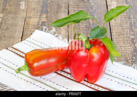 Nur reife Paprika liegen auf dem Handtuch mit Ornament auf Holzbrettern abgeholt. Bulgarische oder Paprika. Stockfoto