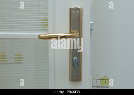 Close-up-Elemente im Inneren der Wohnung. Detail einer weißen Tür innen mit einem Türgriff und Riegel, Stockfoto