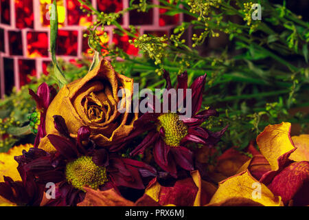 Eine Nahaufnahme von einem schönen Welken Fallen farbigen Blumenstrauß gedämpften Braun, Orangen und Grünen Trocknung sind lebendig und Emotionen wecken. Stockfoto
