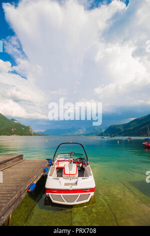 Motorboot in der Nähe von hölzernen Pier auf einem wunderschönen Berg Wolfgangsee in den österreichischen Alpen. Dramatische cloudscape. Stockfoto