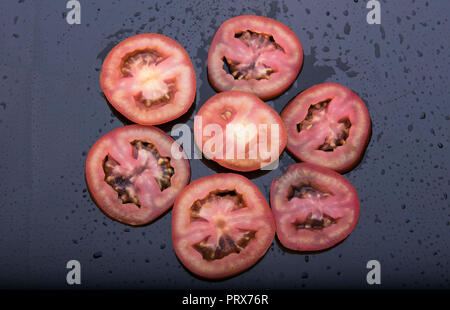 Die in Scheiben geschnittenen Tomaten auf dunklem Hintergrund bei Mumbai Maharashtra Indien isoliert Stockfoto