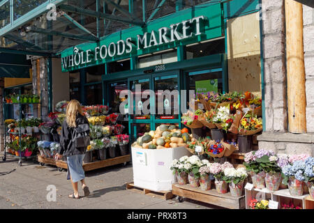 Junge blonde Frau zu Fuß vorbei an der Whole Foods Market auf West 4th Avenue in der Kitsilano-viertels von Vancouver, BC, Kanada Stockfoto