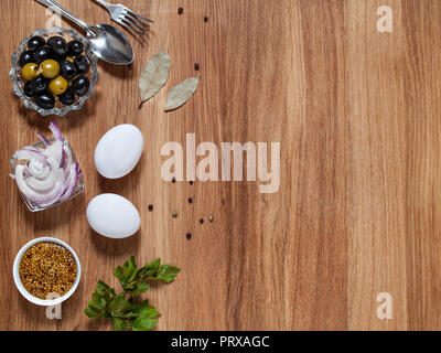 Oliven, Senf, huhn eier, rote Zwiebel, Lorbeerblatt liegen auf einem hölzernen Hintergrund horizontal mit copy-Raum Stockfoto