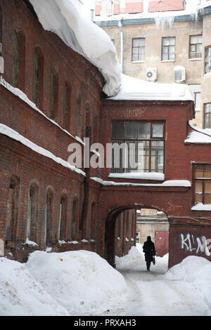 St. Petersburg, Russland; - am 5. Januar 2011: riesiger Haufen Schnee ist aus einem alten Gebäude Dach auf eine Frau unten zu fallen Stockfoto