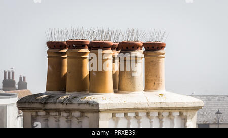 Anti-pigeon Spikes an den Schornsteinen eines Hauses in Großbritannien Stockfoto