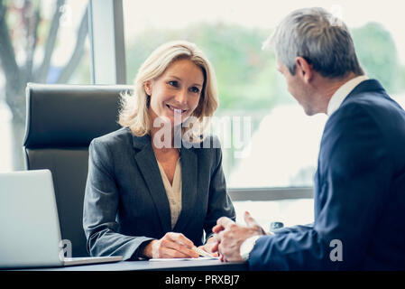 Geschäftsleute, die Schreibarbeit zu diskutieren Stockfoto