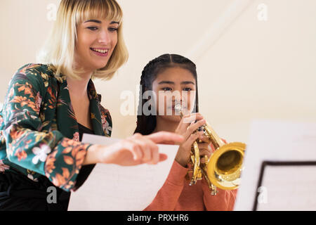 Lehrer helfen weiblichen Kursteilnehmer zu spielen Trompete in der Musik Lektion Stockfoto