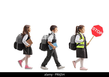 Volle Länge Profil Aufnahme der Schülerinnen und Schüler und eine Schülerin mit einem Stoppschild auf weißem Hintergrund Stockfoto
