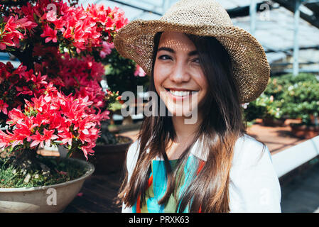 Bonsai Gewächshaus Zentrum. Zeilen mit kleinen Bäumen, Frau arbeiten und der Pflege der Pflanzen Stockfoto