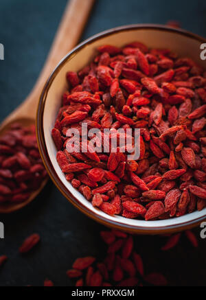 Close-up von getrockneten Goji Beeren in der Schüssel auf dunklem Hintergrund Stockfoto