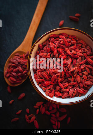 Close-up von getrockneten Goji Beeren in der Schüssel auf dunklem Hintergrund Stockfoto