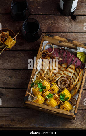 Pastrami und gegrilltem Mais in Holzbox, flach Stockfoto