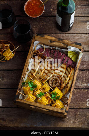 Pastrami und gegrilltem Mais in Holzbox, flach Stockfoto