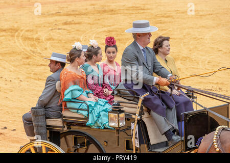 Sevilla, Spanien - 15 April, 2018: Junge Frauen tragen traditionelle Sevillana Kleider oder flamenca Kleider in einer Kutsche in Sevilla April Fai Stockfoto