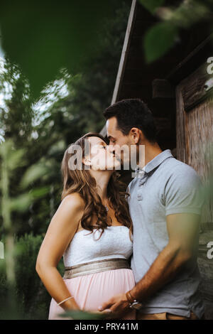 Mann, ist das Küssen seine schwangere Frau Stockfoto
