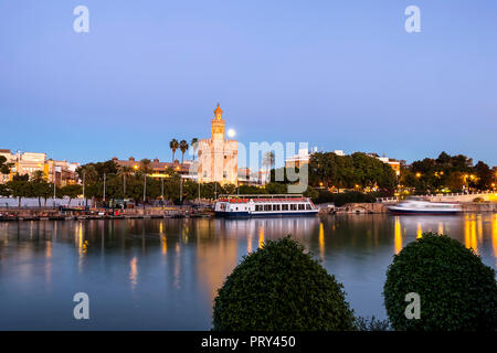 Lange Exposition der Goldene Turm (Torre del Oro) bei Sonnenuntergang von der anderen Seite des Flusses Guadalquivir mit Vollmond, Sevilla (Andalusien), Spai Stockfoto