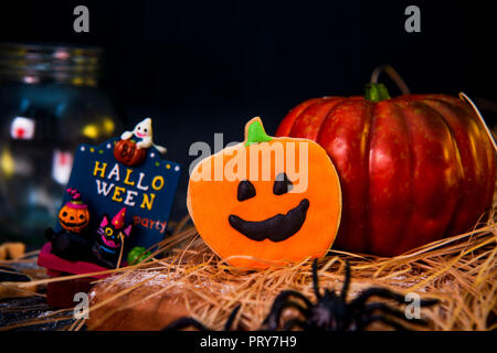 Frische hausgemachte verziert halloween Kekse und Süßigkeiten auf dunklem Hintergrund, Konzept der Halloween Monster party, kopieren Platz, in der Nähe Stockfoto