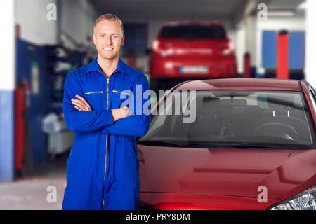 Portrait eines glücklichen Männlichen Automechaniker Stehen mit verschränkten Armen Stockfoto
