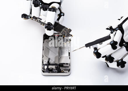 Roboterhand Reparatur Handy auf weißem Hintergrund Stockfoto