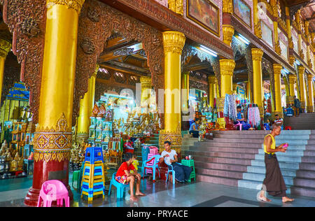 YANGON, MYANMAR - 27. FEBRUAR 2018: Die Hänge des Singuttara Hill, gekrönt mit der Shwedagon Pagode, sind mit überdachten Galerien dieses Heiligen belegt Stockfoto