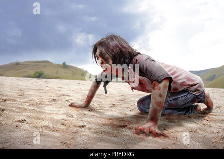 Wütende zombie Mann kriecht mit Händen und Knien auf dem Sand dune Stockfoto