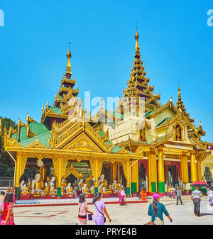 YANGON, MYANMAR - 27. FEBRUAR 2018: Die hohen pyatthat (multistaged) Dach der westlichen Treppe Pavillon der Shwedagon Pagode und die schöne Koo Stockfoto