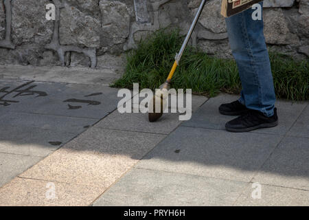 Menschen mit Wasser und Bürste Chniese Kalligraphie zu üben im öffentlichen Park in Xi'an, Shaanxi, China. Stockfoto