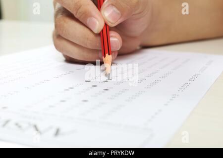 Man füllt OME-Blatt mit Bleistift in der Hand für Bild. auf weißem Hintergrund. Stockfoto