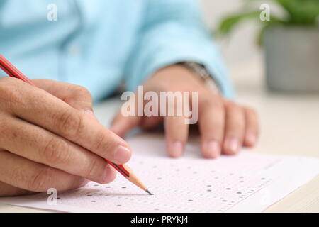 Bild von Mann füllt OME-Blatt mit Bleistift. Stockfoto