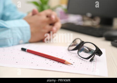 Bild von Bleistift und Gläser auf der OME-Blatt. Bild von Computer auf dem Tisch. Stockfoto