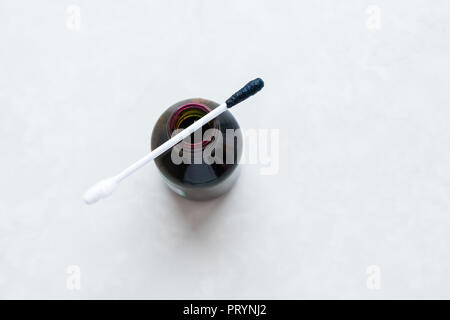 Ein Mann verwendet ein grünes Antiseptikum, hält einen Wattestäbchen in den Händen. Zelenka in einer Flasche. Stockfoto