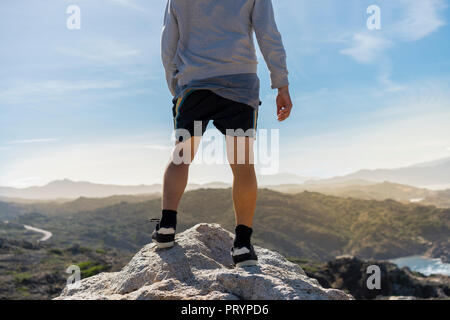 Mann, sitzen auf den Felsen, mit Blick auf das Meer Stockfoto