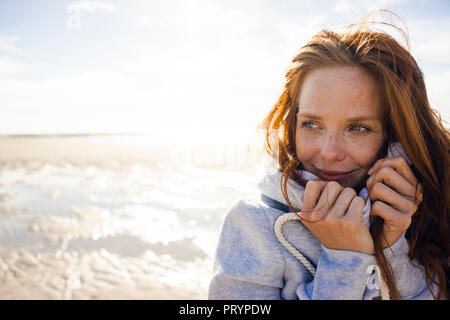 Rothaarige Frau genießen die frische Luft am Strand Stockfoto