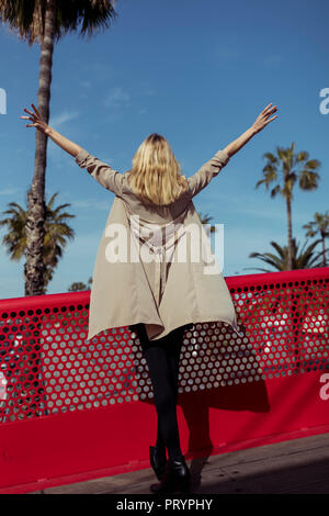 Rückansicht des modischen jungen Frau tragen beige Mantel Stockfoto