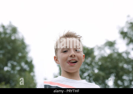 Porträt der blonde Junge heraus haften Zunge Stockfoto