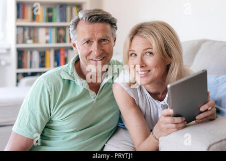 Portrait von lächelnden Reifes Paar zu Hause mit Tablet Stockfoto