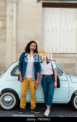 Porträt eines jungen Paares bei Kleinwagen Stockfoto