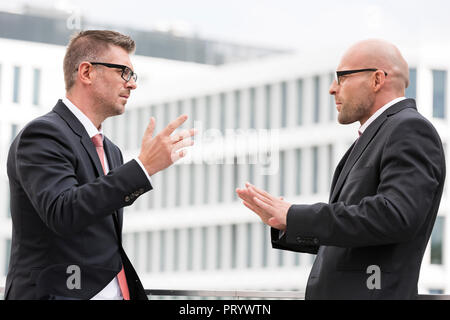 Polen, Warzawa, zwei Geschäftsleute gestikulieren Stockfoto