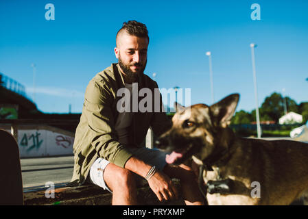 Portrait von Inhalt junger Mann mit seinem Hund Stockfoto