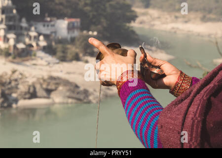 Frau mit Weihrauch in hand Puja vor heiligen Fluss Ganges Rishikesh Indien Stockfoto