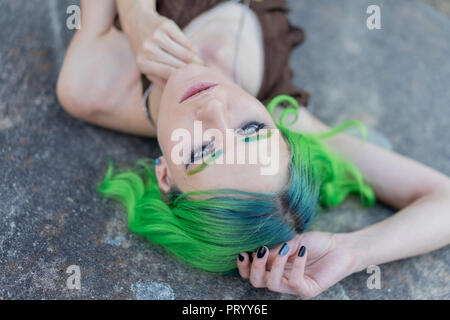 Portrait von Träumen junge Frau mit gefärbten grüne Haare und Augenbrauen in der Natur Stockfoto