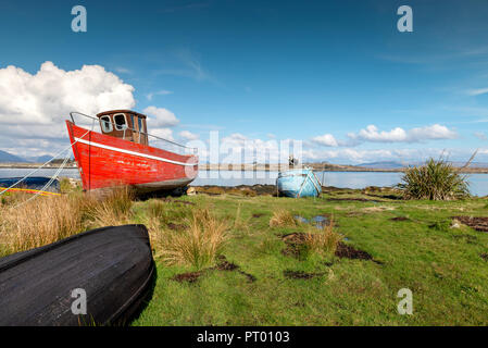 Roundstone, Connemara, Galway, Irland, 04/2018, heruntergekommene Fischerboote links nach Verfall neben der Bucht von Connemara. Stockfoto