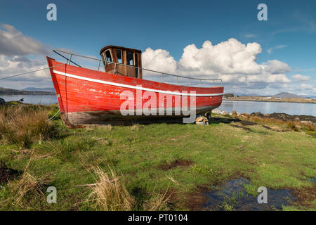 Roundstone, Connemara, Galway, Irland, 04/2018, heruntergekommene Fischerboote links nach Verfall neben der Bucht von Connemara. Stockfoto