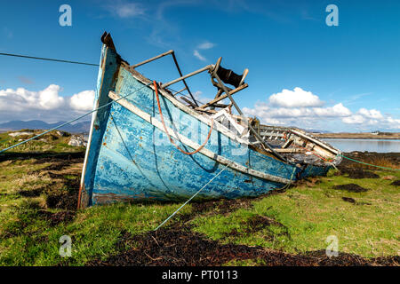 Roundstone, Connemara, Galway, Irland, 04/2018, heruntergekommene Fischerboote links nach Verfall neben der Bucht von Connemara. Stockfoto